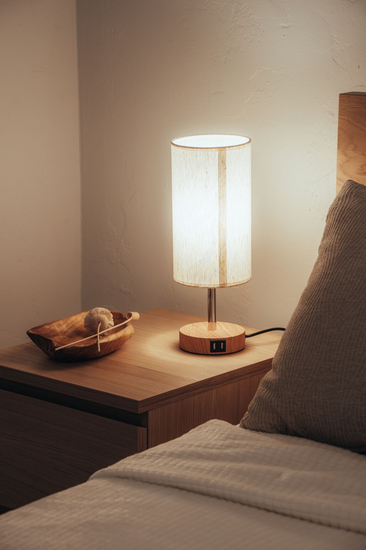Lampe de chevet allumée à portée de main près du lit, la nuit