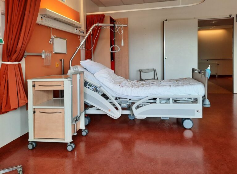 Lit médicalisé avec barrières latérales relevées dans une chambre