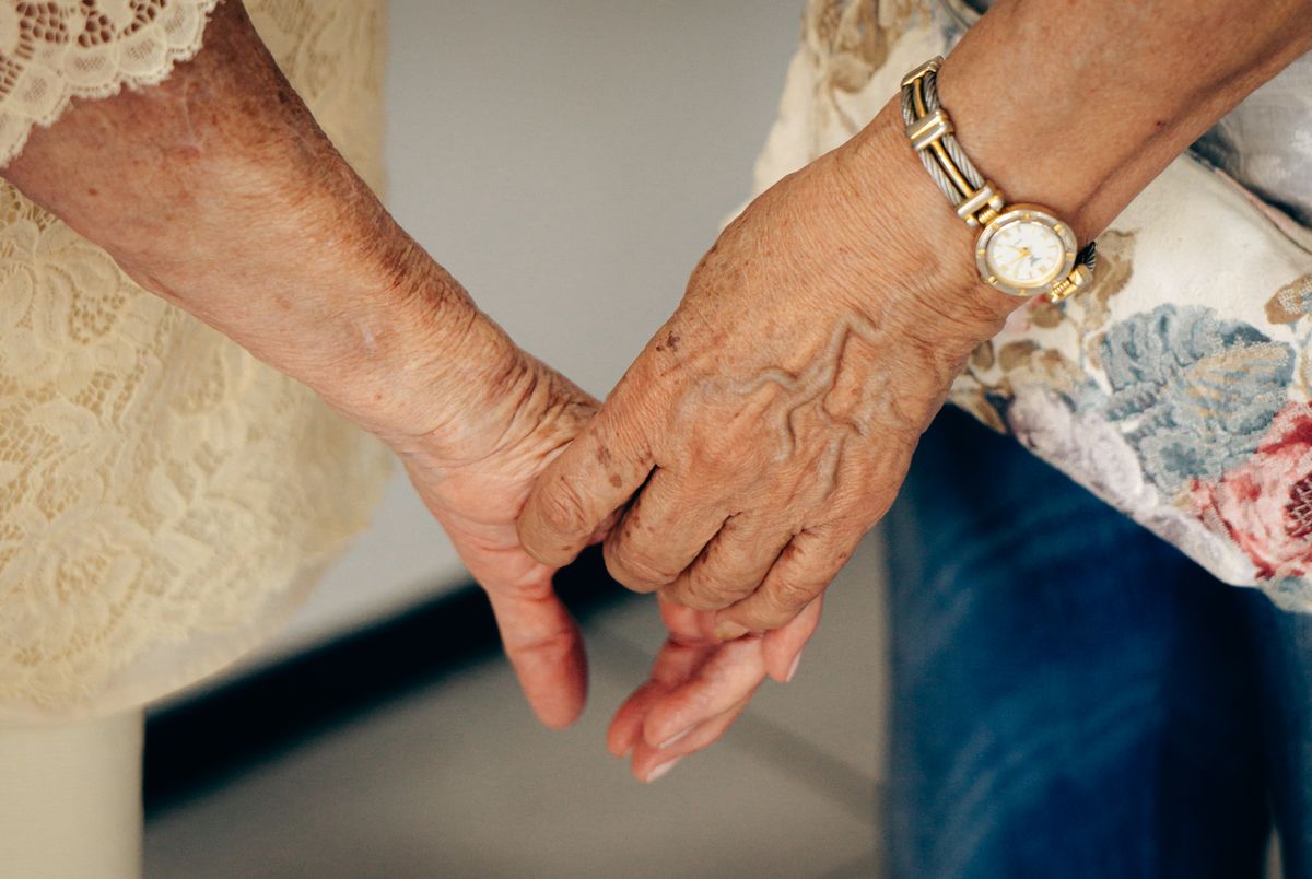 Mains d'une personne âgée tenues avec douceur