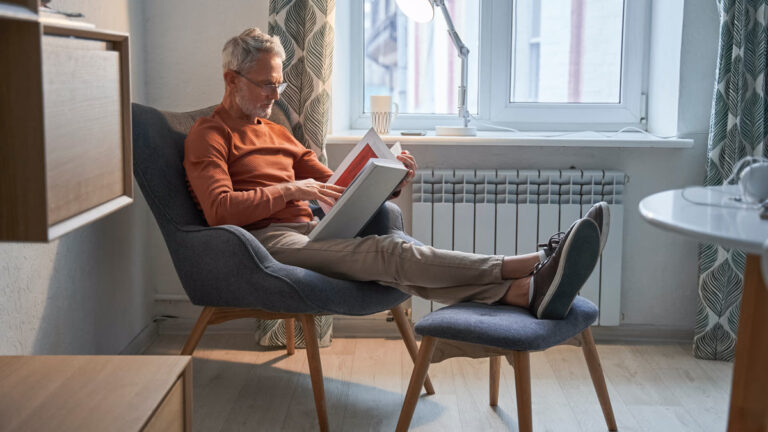 Homme âgé détendu lisant dans son fauteuil