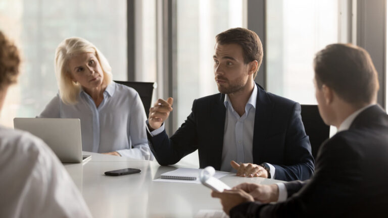 Frères et sœurs adultes en discussion sérieuse autour d'une table