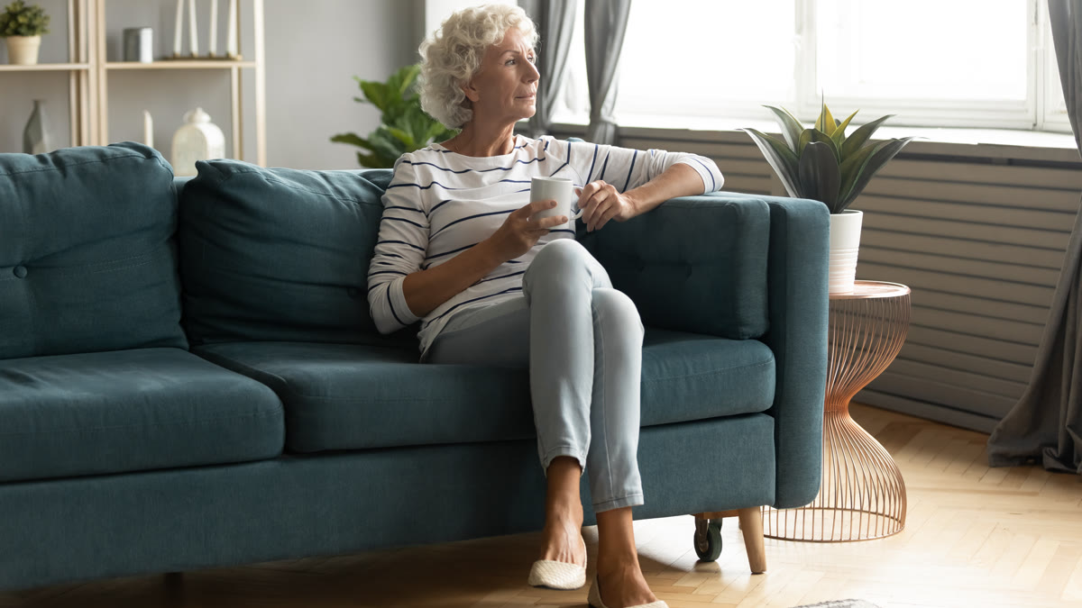 Femme âgée assise près de la fenêtre en fin de journée
