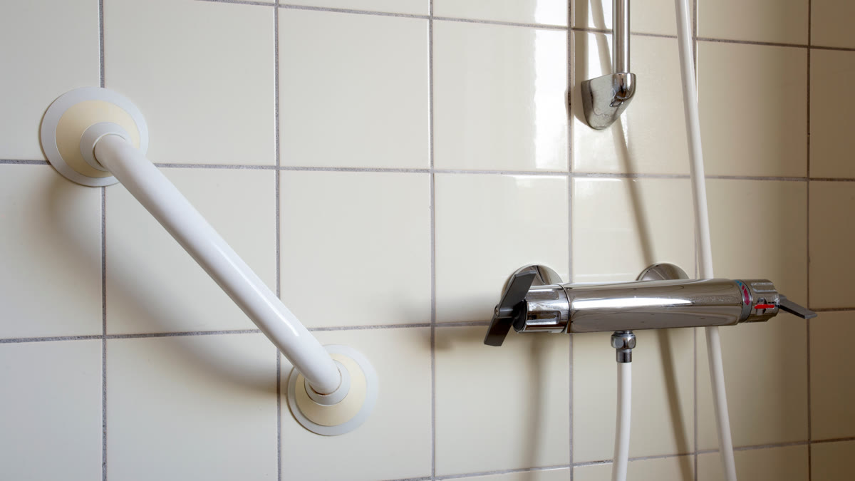 Douche équipée d'une barre d'appui et d'un siège pour senior