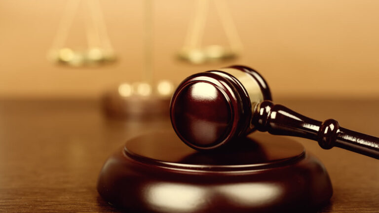 Balance de la justice et marteau sur un bureau en bois