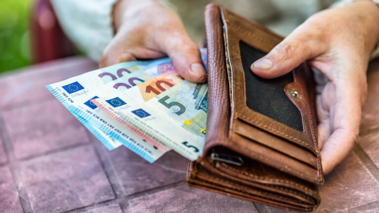 Femme retraitée tenant un portefeuille avec des billets