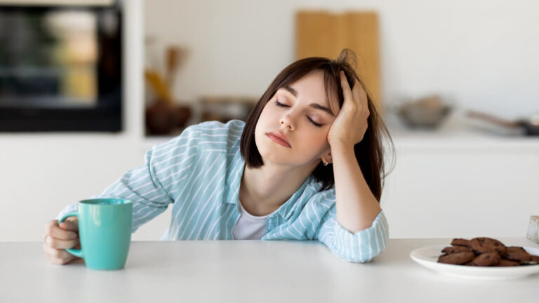 Femme fatiguée dans sa cuisine avec un café