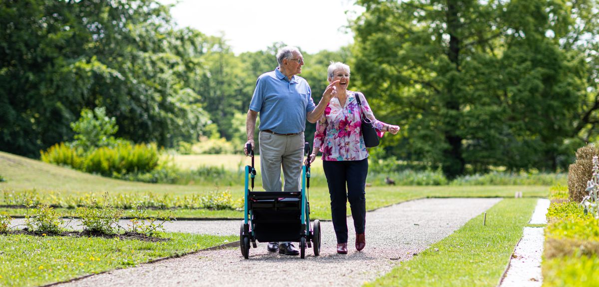 Couple de seniors se promenant avec un rollator au parc