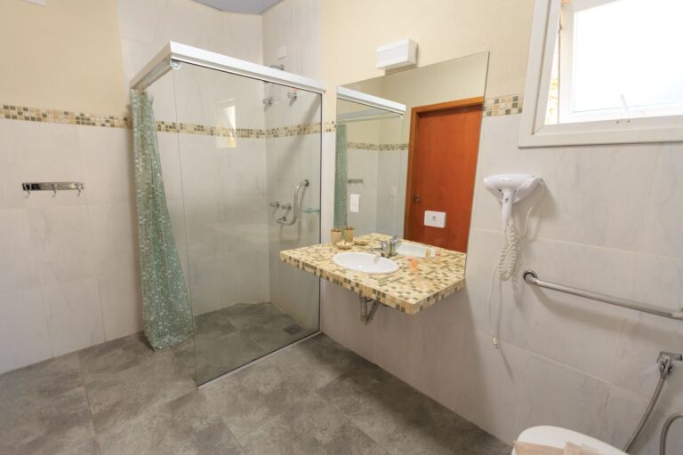 Salle de bain adaptée avec douche de plain-pied, barres d'appui et lavabo accessible