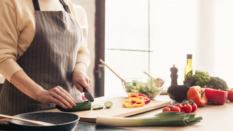 Femme âgée cuisinant sur sa gazinière