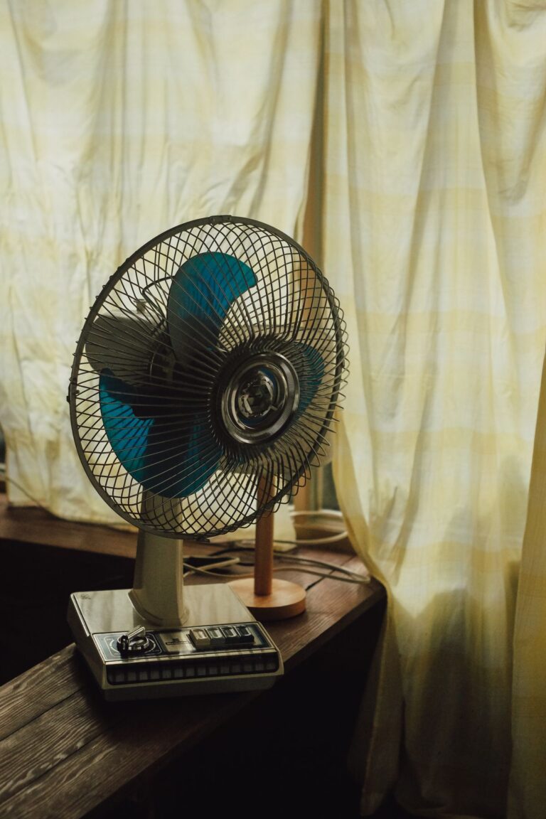 Ventilateur posé près d'une fenêtre dans une chambre en été