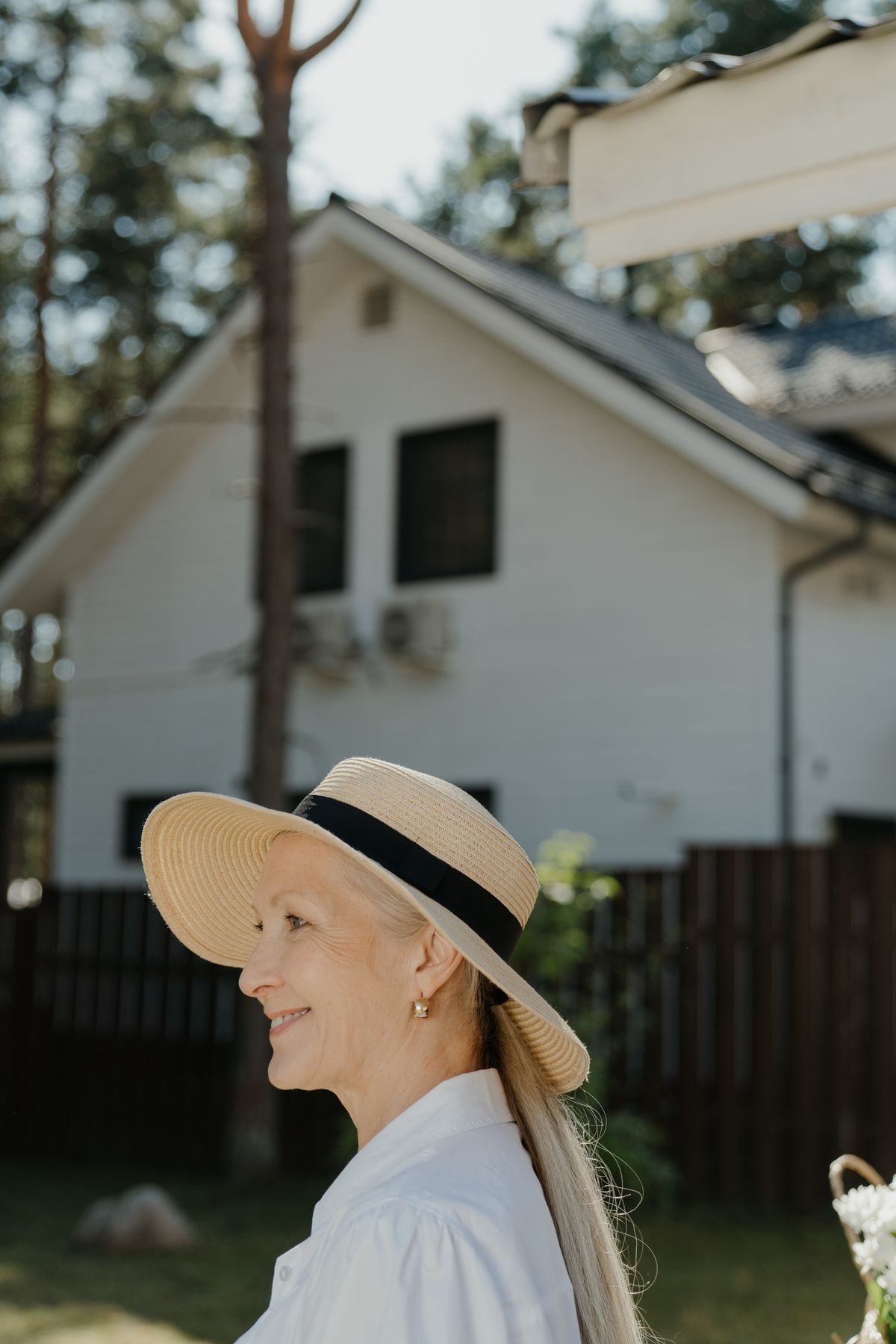 Femme âgée portant un chapeau de paille à large bord et une chemise claire en été