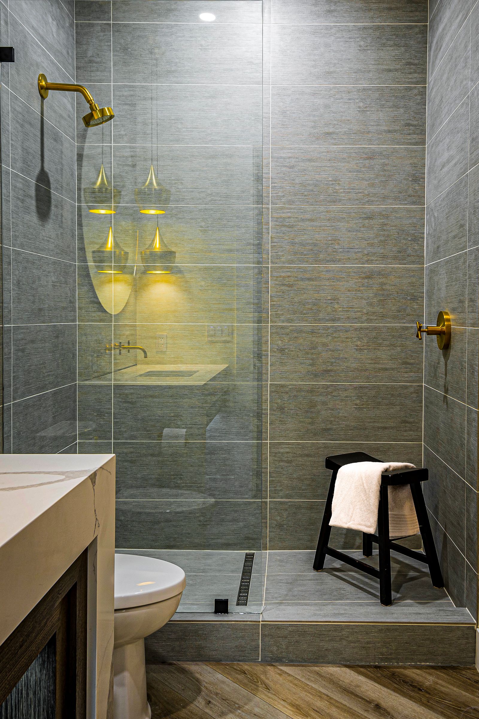 Salle de bain lumineuse avec douche et tabouret