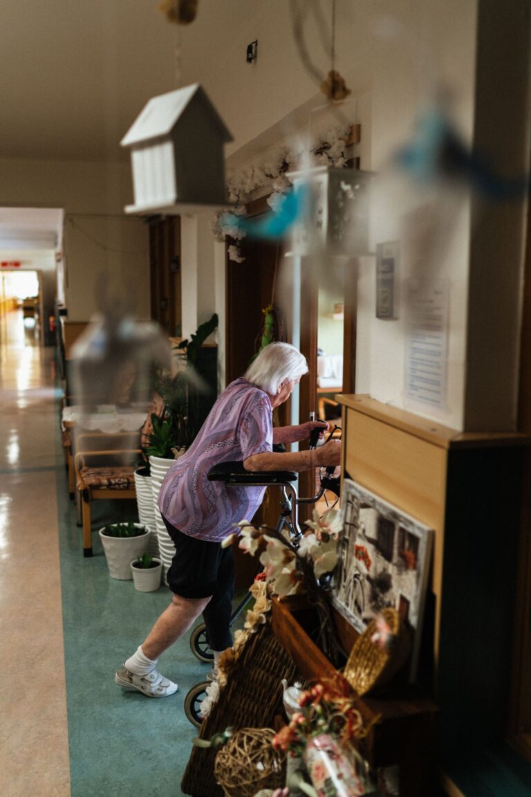 Femme âgée avec déambulateur dans un couloir