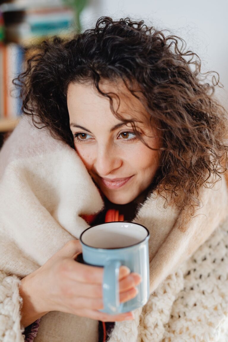 Femme enveloppée dans un plaid avec une tasse, moment de bien-être pour l'aidante