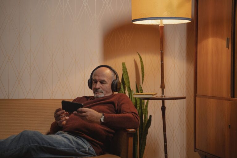 Homme âgé portant un casque audio dans son salon