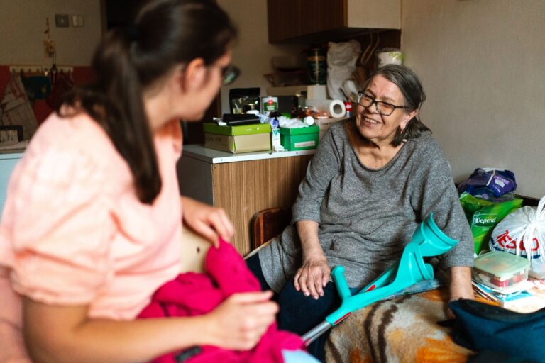 Aidante aidant une femme âgée à se redresser avec une béquille