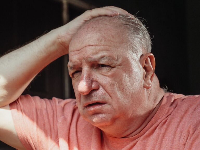 Homme âgé désorienté, main sur la tête, confusion aiguë