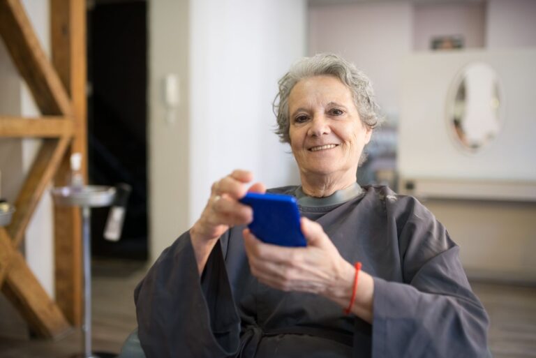 Femme âgée souriante avec son smartphone