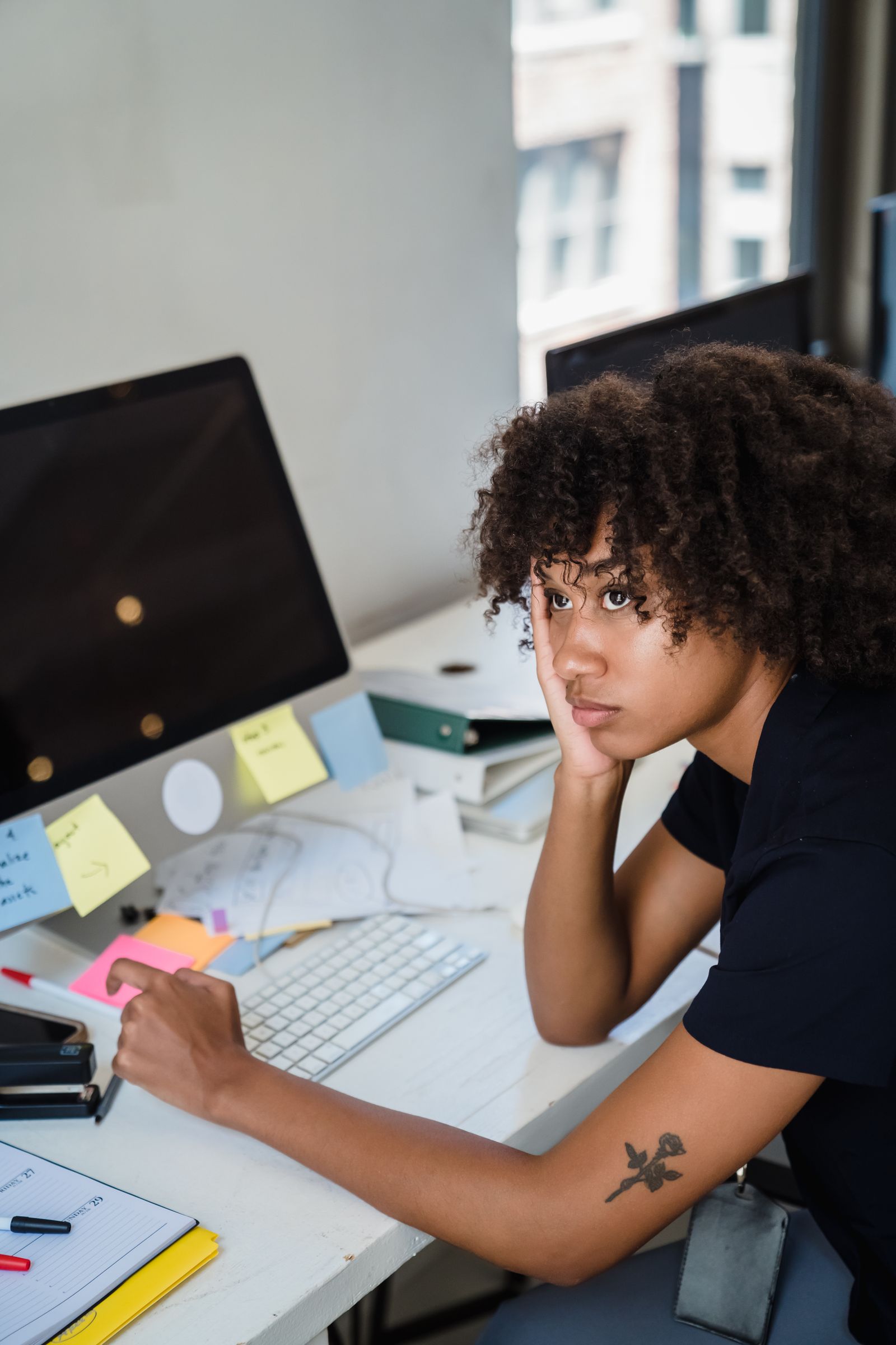Femme débordée par la paperasse à son bureau