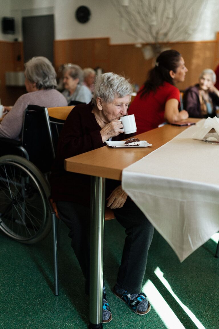 Personne âgée frêle attablée devant un repas léger
