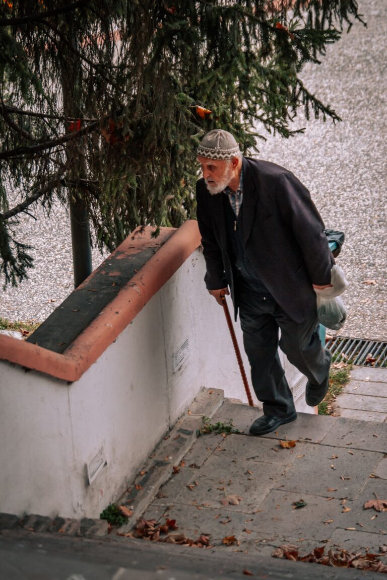 Homme âgé montant des marches avec sa canne