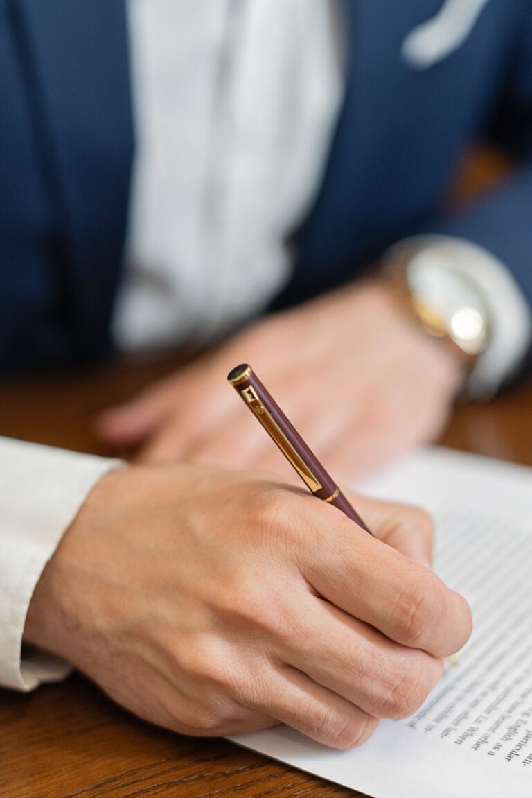 Main signant un document officiel au stylo