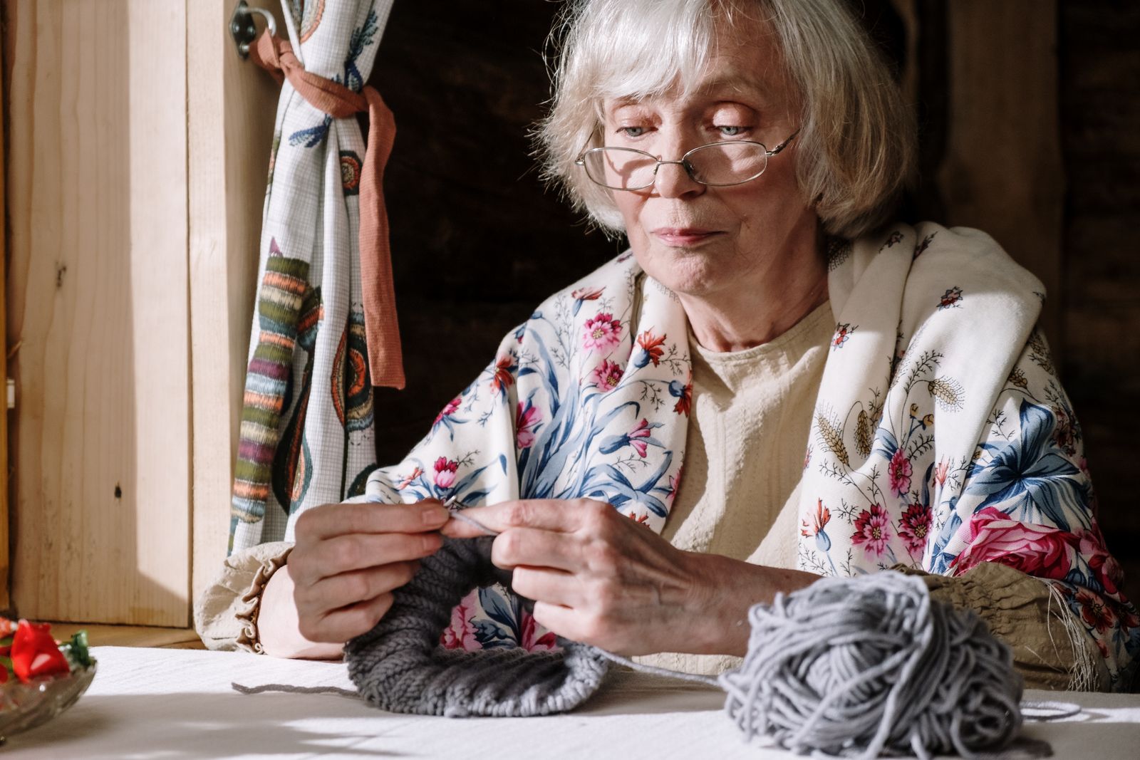 Grand-mère tricotant près de la fenêtre