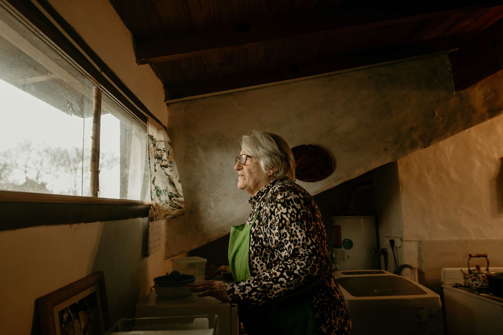 Femme âgée près d'une fenêtre en fin de journée, syndrome crépusculaire