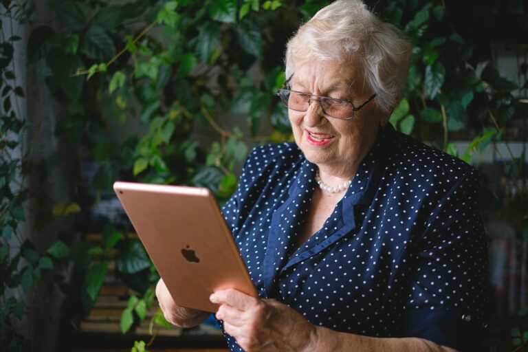 Femme âgée souriante en téléconsultation sur sa tablette