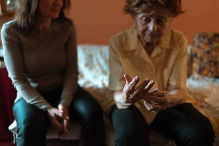 Aidante tenant les mains d'une femme âgée agitée pour l'apaiser
