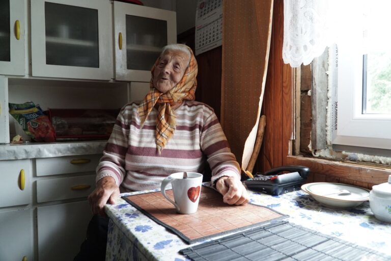 Femme âgée en pull avec une tasse de thé