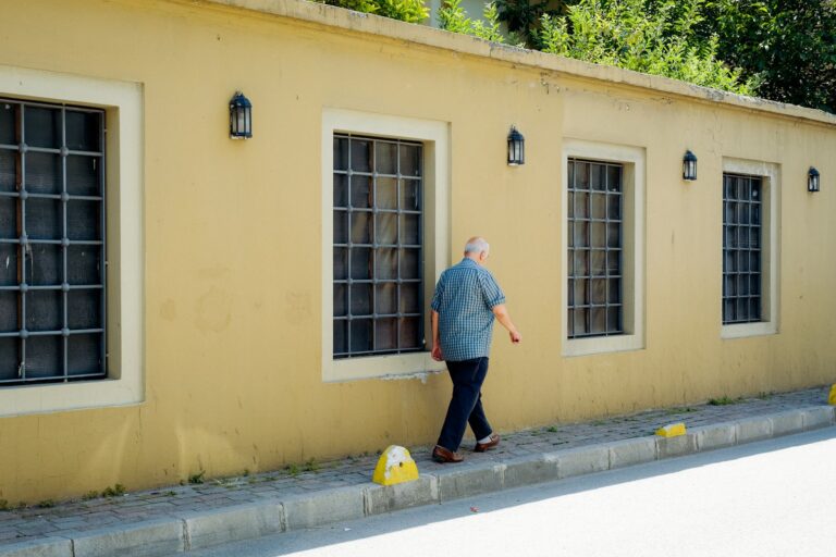 Homme âgé marchant seul dans la rue par une journée ensoleillée