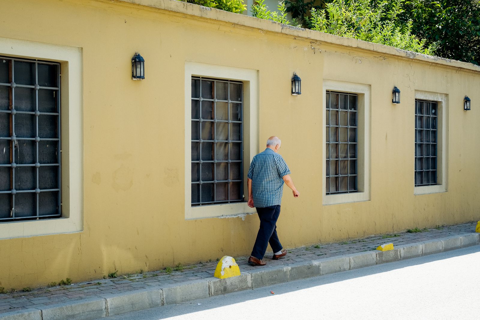 Homme âgé marchant seul dans la rue par une journée ensoleillée