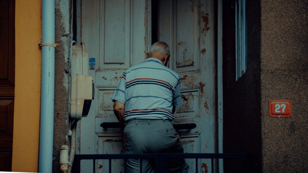 Homme âgé passant une porte vers l'extérieur