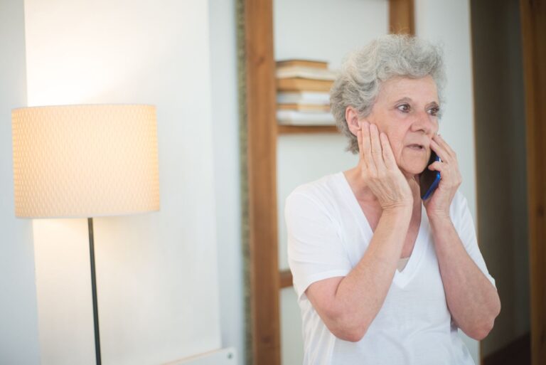 Femme âgée au téléphone, l'air préoccupé
