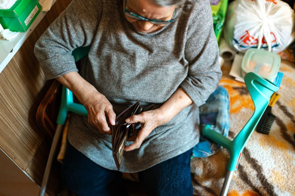 Femme âgée ouvrant son porte-monnaie