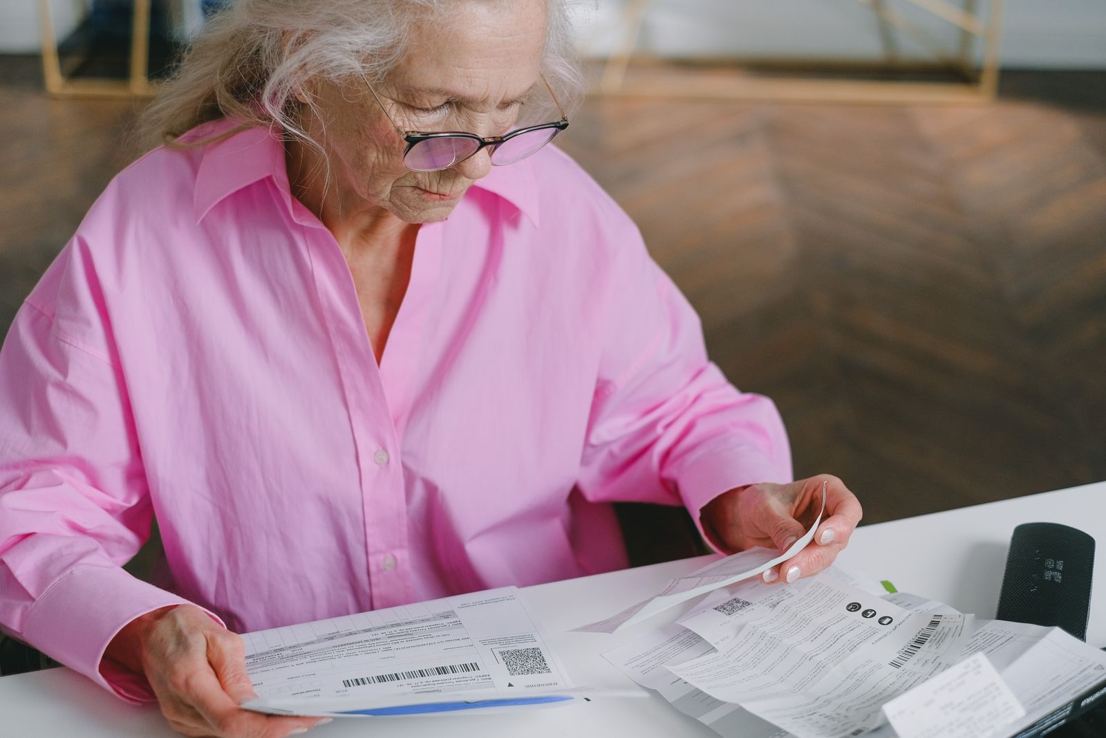 Femme âgée lisant des documents à sa table