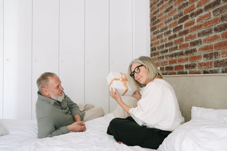 Couple âgé échangeant un cadeau dans une chambre confortable