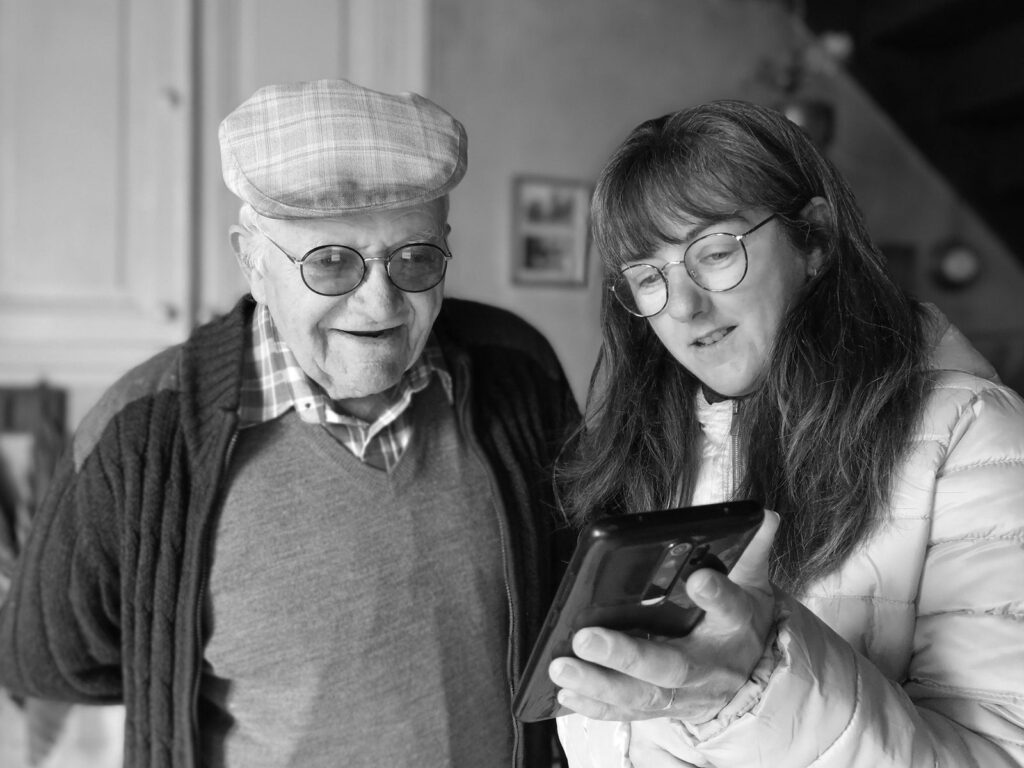 Homme âgé et sa fille regardant ensemble un téléphone
