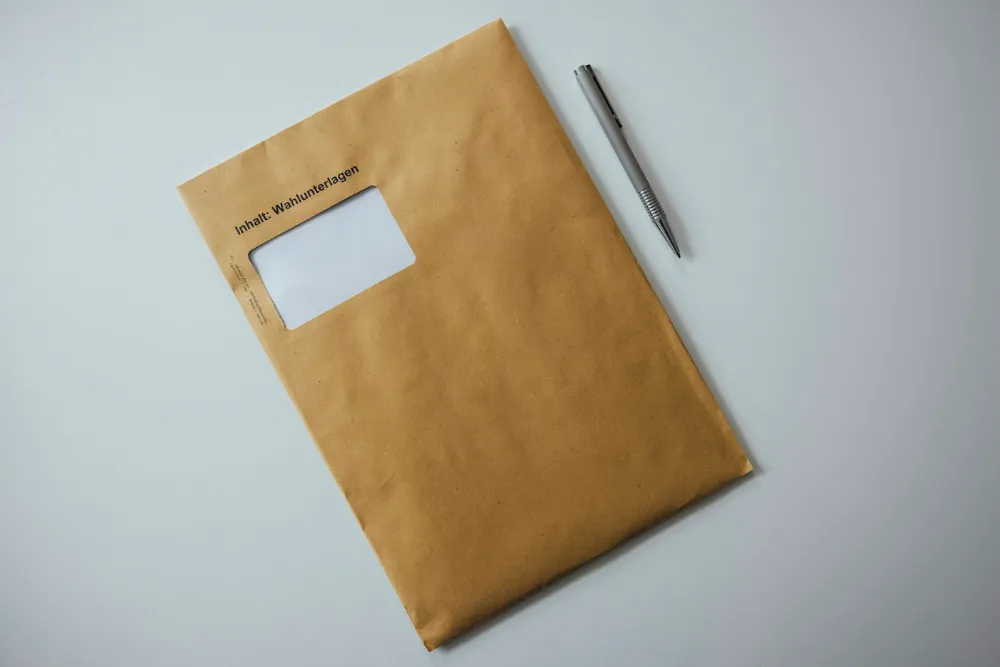 Grande enveloppe kraft et stylo posés sur un bureau, prêts pour un courrier recommandé