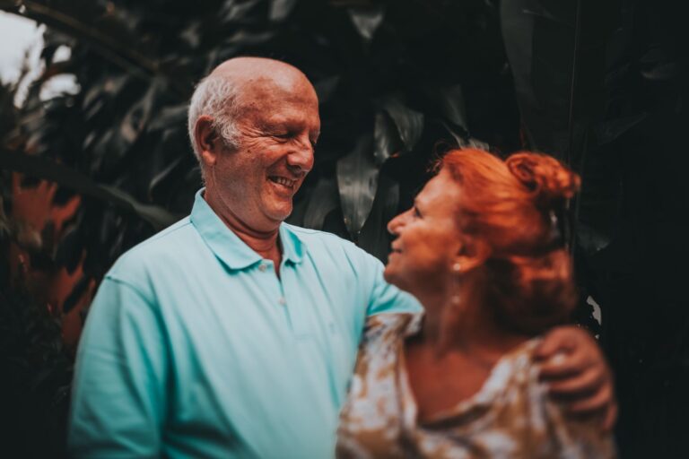 Couple âgé souriant et enlacé en plein air