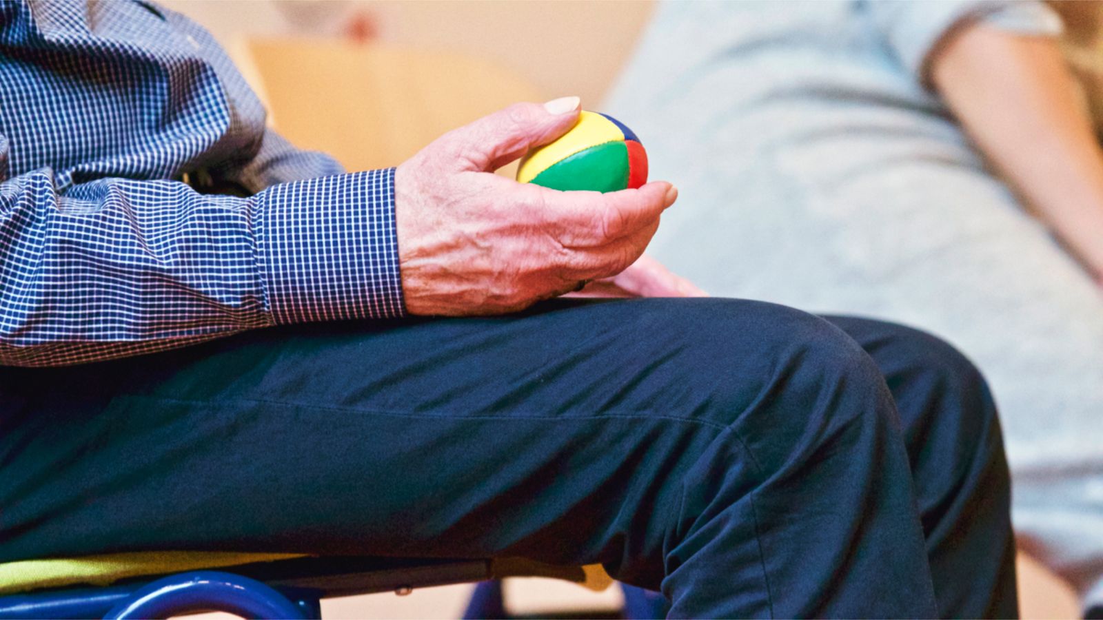 Homme âgé tenant un ballon de thérapie lors d'une séance