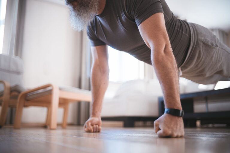 Homme âgé faisant ses exercices au sol dans son salon