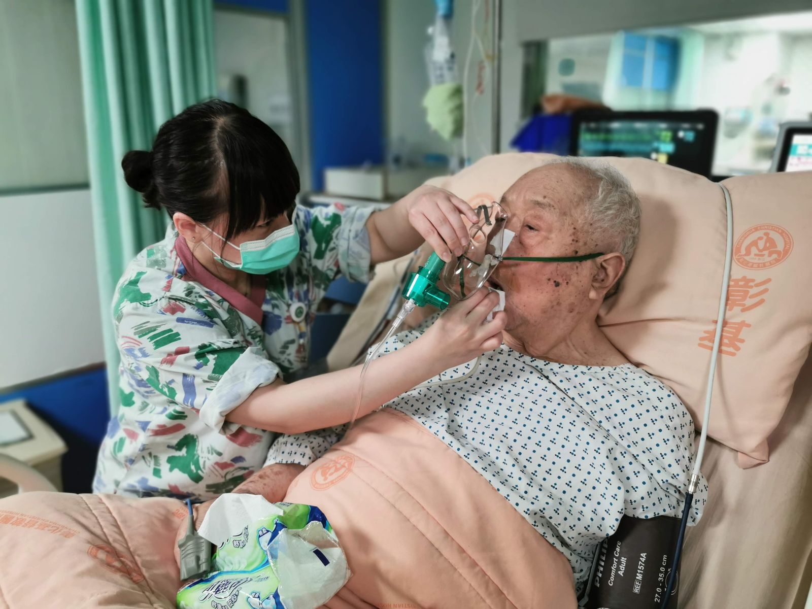 Infirmière auprès d'un patient âgé dans un lit d'hôpital