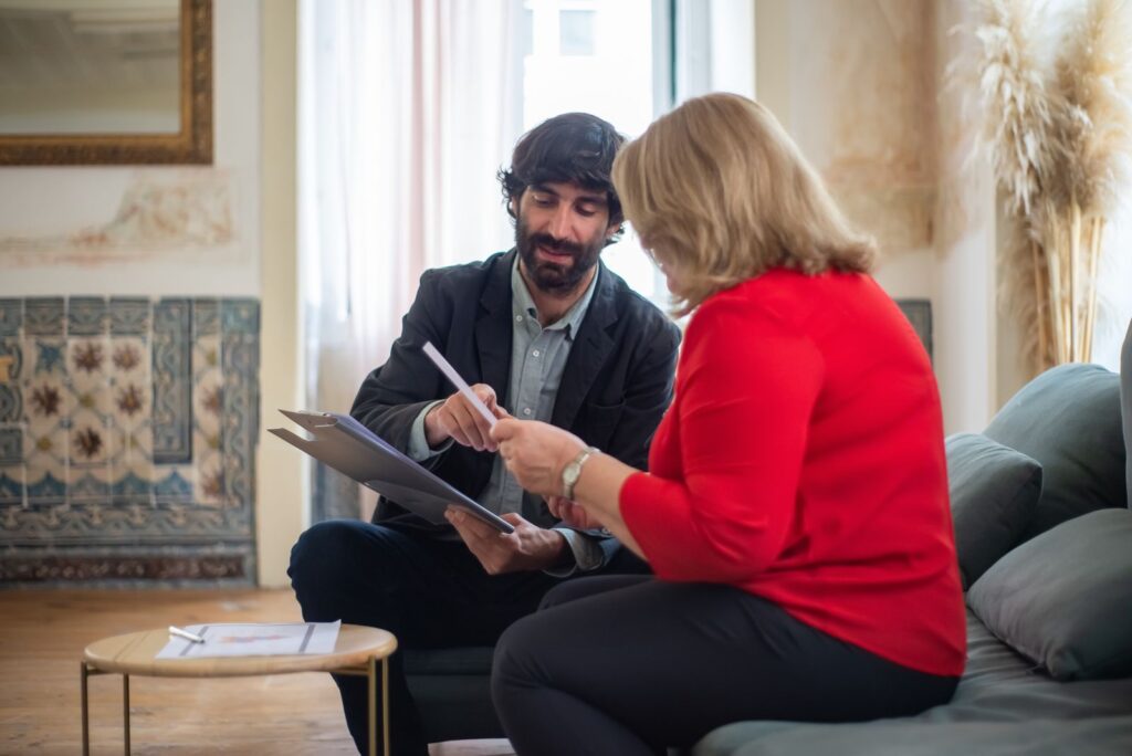 Femme âgée échangeant avec un conseiller sur son canapé