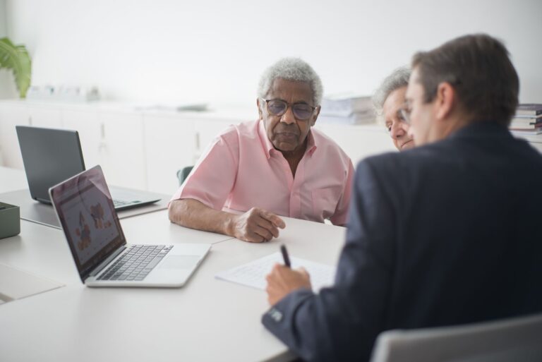 Couple âgé échangeant avec une conseillère dans un bureau