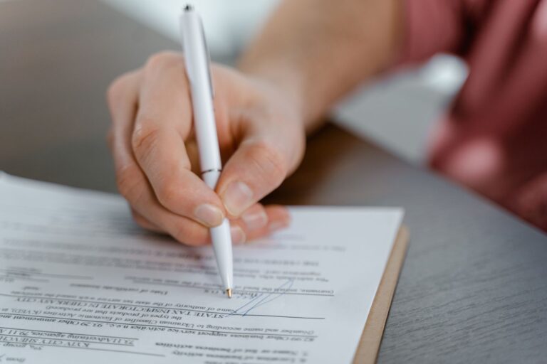 Main signant un document officiel avec un stylo