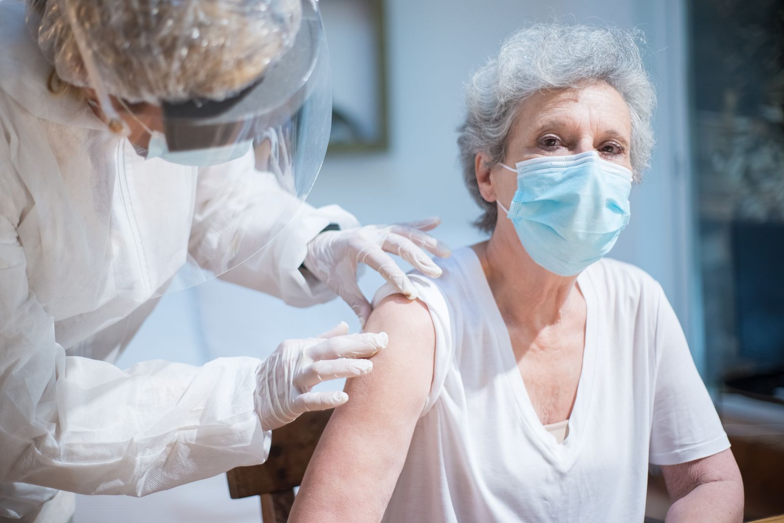 Femme âgée se faisant vacciner par une soignante